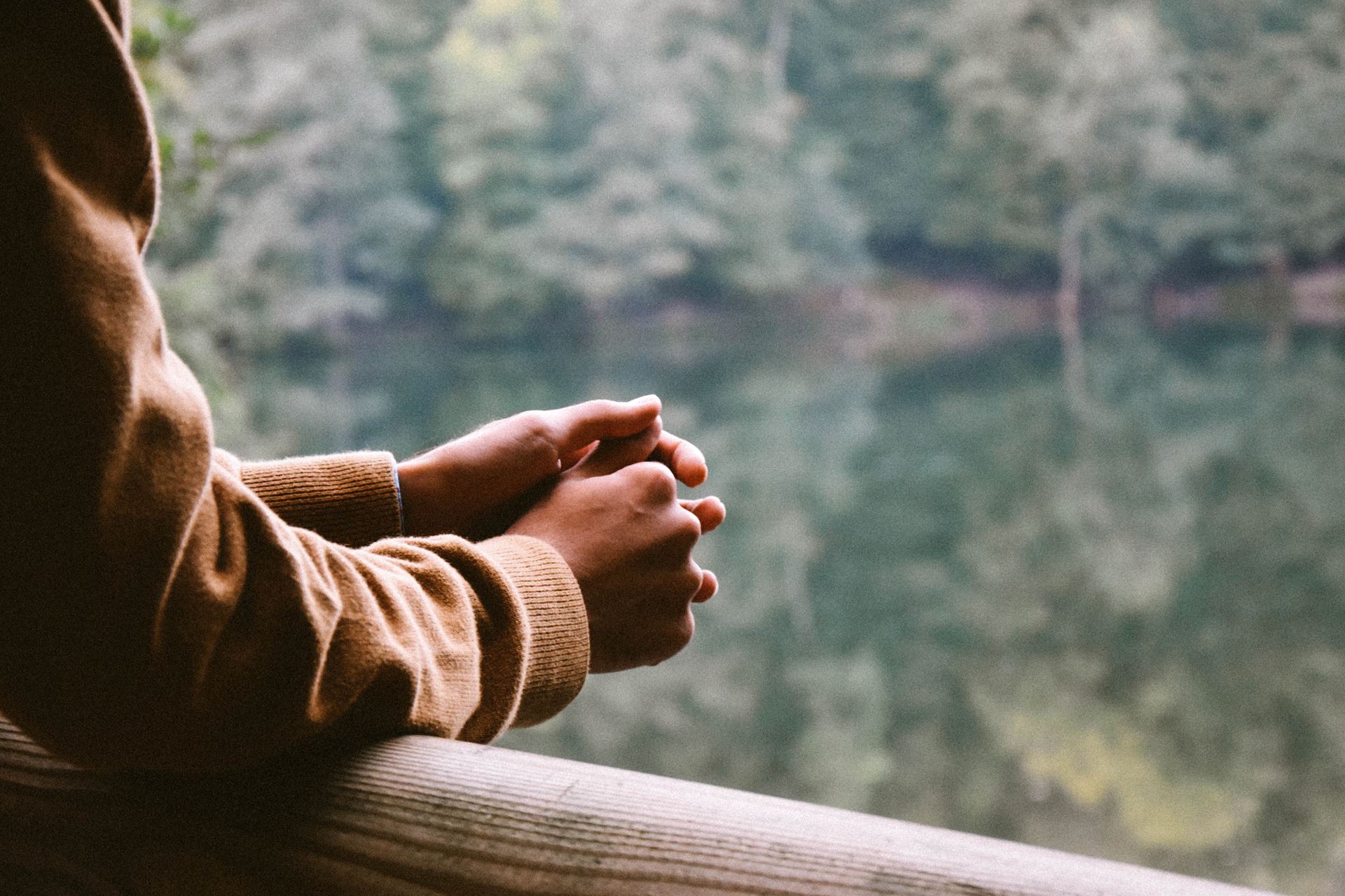 a person leaning on the bridge looking pensive